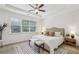Bright main bedroom boasts a ceiling fan, tray ceiling, a large window, and neutral colors at 1986 Cobblestone Ne Cir, Atlanta, GA 30319