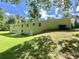Expansive backyard view of the brick home with a gentle slope and mature trees surrounding the landscape at 3975 N Sharon Church N Rd, Loganville, GA 30052