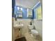 Blue bathroom with a white vanity, tiled walls, and a window for natural light at 3975 N Sharon Church N Rd, Loganville, GA 30052