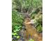 A tranquil creek meanders through the verdant landscape of this beautiful property at 3975 N Sharon Church N Rd, Loganville, GA 30052