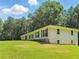 Exterior side view of the ranch-style home featuring manicured lawn and mature trees at 3975 N Sharon Church N Rd, Loganville, GA 30052