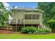 Exterior view of a two-story home, showcasing a spacious deck, a screened porch, and a lush, landscaped backyard at 526 Summer Ter, Woodstock, GA 30189