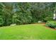 Well-manicured lawn with lush green grass, landscaping, and mature trees, creating a private outdoor oasis at 526 Summer Ter, Woodstock, GA 30189