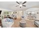 Open-concept living room with white furniture, a ceiling fan, and arched doorway to kitchen at 526 Summer Ter, Woodstock, GA 30189