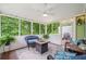 Relaxing screened porch featuring comfortable seating, a ceiling fan, and views of the surrounding greenery at 526 Summer Ter, Woodstock, GA 30189