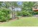 Exterior view of a backyard featuring a wooden fence, patio, and trees at 571 Oak Vista Ct, Lawrenceville, GA 30044