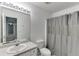 Simple bathroom featuring a gray shower curtain, a white toilet, and a large mirror over the sink at 571 Oak Vista Ct, Lawrenceville, GA 30044