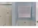 A clean bathroom features a shower with swan decorations, a window with blinds, and a white bathtub at 571 Oak Vista Ct, Lawrenceville, GA 30044