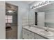 Bright bathroom featuring a double vanity, and a mirror reflecting a bedroom with a ceiling fan at 571 Oak Vista Ct, Lawrenceville, GA 30044