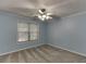 Bright bedroom with light blue walls, carpet flooring, a ceiling fan, and a window at 571 Oak Vista Ct, Lawrenceville, GA 30044