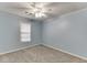 A serene bedroom with light blue walls, carpet flooring, a ceiling fan, and a window at 571 Oak Vista Ct, Lawrenceville, GA 30044