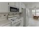 Bright eat-in kitchen features white appliances, cabinetry and breakfast nook at 571 Oak Vista Ct, Lawrenceville, GA 30044