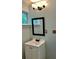 Clean bathroom featuring a framed mirror, simple vanity, and wooden outlet covers at 6906 Shangrila Way, Riverdale, GA 30296