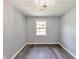 This bedroom features gray walls, wood flooring, a window and modern lighting at 6906 Shangrila Way, Riverdale, GA 30296