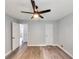 This bedroom has light grey walls, wood flooring, and a ceiling fan at 6906 Shangrila Way, Riverdale, GA 30296