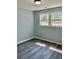 Bright bedroom featuring new floors, fresh paint, a modern light fixture, and ample natural light at 6906 Shangrila Way, Riverdale, GA 30296