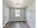 This bedroom features gray walls, wood flooring, and a window with natural light at 6906 Shangrila Way, Riverdale, GA 30296
