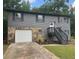Charming two-story home featuring a stone facade, gray siding, and a well-maintained front yard with flower beds at 6906 Shangrila Way, Riverdale, GA 30296
