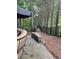 Exterior stone patio with comfortable chair and beautiful view of the fenced backyard at 3930 Regal Oaks Dr, Suwanee, GA 30024