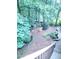 Lush backyard featuring a stone-lined garden, mature trees, and a mulched landscape at 3930 Regal Oaks Dr, Suwanee, GA 30024