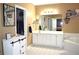 Bathroom featuring a double vanity with white cabinets and large tub at 3930 Regal Oaks Dr, Suwanee, GA 30024