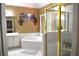 Bright bathroom featuring a soaking tub, white tile, and a glass-enclosed shower at 3930 Regal Oaks Dr, Suwanee, GA 30024