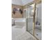 Bathroom featuring a bathtub, shower with gold trim, a mirror, and a small window at 3930 Regal Oaks Dr, Suwanee, GA 30024