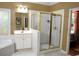 Well-lit bathroom with white cabinets, large mirror, and a tiled shower at 3930 Regal Oaks Dr, Suwanee, GA 30024