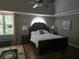 Bedroom with dark wood bed, matching side tables, and large windows for lots of natural light at 3930 Regal Oaks Dr, Suwanee, GA 30024