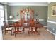 Elegant dining room boasts a wooden table set and matching china cabinet under a decorative chandelier at 3930 Regal Oaks Dr, Suwanee, GA 30024