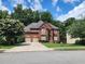 Charming two-story home with lush landscaping, mature trees, and a well-manicured lawn at 3930 Regal Oaks Dr, Suwanee, GA 30024