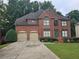 Traditional two-story brick home with a two-car garage, manicured lawn, and mature trees at 3930 Regal Oaks Dr, Suwanee, GA 30024