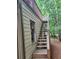 Exterior stairs leading to a raised deck or patio area with a view of the trees at 3930 Regal Oaks Dr, Suwanee, GA 30024