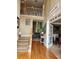 Open foyer with hardwood floors, stairs, and view into living room and office space at 3930 Regal Oaks Dr, Suwanee, GA 30024