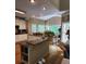 Open-concept kitchen featuring an island with seating, hardwood floors, and natural light at 3930 Regal Oaks Dr, Suwanee, GA 30024