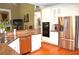 Open kitchen with stainless steel appliances, granite countertops, and view to fireplace and living room at 3930 Regal Oaks Dr, Suwanee, GA 30024