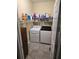 Practical laundry room with modern washer and dryer, plus storage shelves at 3930 Regal Oaks Dr, Suwanee, GA 30024