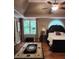 This main bedroom features a ceiling fan, a large window, and hardwood floors at 3930 Regal Oaks Dr, Suwanee, GA 30024