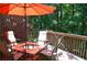 Outdoor patio featuring a dining table with a bright orange umbrella and wood surroundings at 3930 Regal Oaks Dr, Suwanee, GA 30024