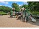 Community playground with climbing structures, slides, and safety ground cover surrounded by mature trees at 3930 Regal Oaks Dr, Suwanee, GA 30024