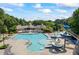 Community pool with slides, clubhouse, chairs, umbrellas and lounge area surrounded by lush greenery at 3930 Regal Oaks Dr, Suwanee, GA 30024