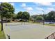 Outdoor tennis courts near pavilion with benches surrounded by lush, mature landscaping and trees at 3930 Regal Oaks Dr, Suwanee, GA 30024