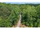 Scenic aerial view of a concrete walkway through a beautiful, lush green forest at 3930 Regal Oaks Dr, Suwanee, GA 30024