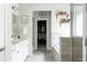 Bathroom featuring double vanity sinks, marble countertops, and a glass-enclosed shower and bathtub at 2099 Lakeview Bend Way, Buford, GA 30519