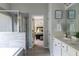 Bright bathroom featuring a soaking tub, glass shower, dual vanity, and adjacent bedroom at 2099 Lakeview Bend Way, Buford, GA 30519