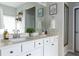 Bright bathroom with dual sinks, white cabinetry, and stylish accents like framed prints and fresh greenery at 2099 Lakeview Bend Way, Buford, GA 30519