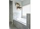 Elegant bathroom showcases a soaking tub with wall-mounted shelving and a view to the window at 2099 Lakeview Bend Way, Buford, GA 30519