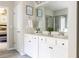 Light and airy bathroom with double sinks, white cabinets, and a view into the main bedroom at 2099 Lakeview Bend Way, Buford, GA 30519