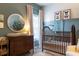 Bright Bedroom featuring a wooden crib, dresser with changing station, and natural light from the window at 2099 Lakeview Bend Way, Buford, GA 30519