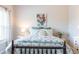 Comfortable bedroom featuring a bed with patterned bedding, decorative pillows, and bright light at 2099 Lakeview Bend Way, Buford, GA 30519